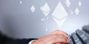 Ethereum logos hovering over hands typing on keyboard