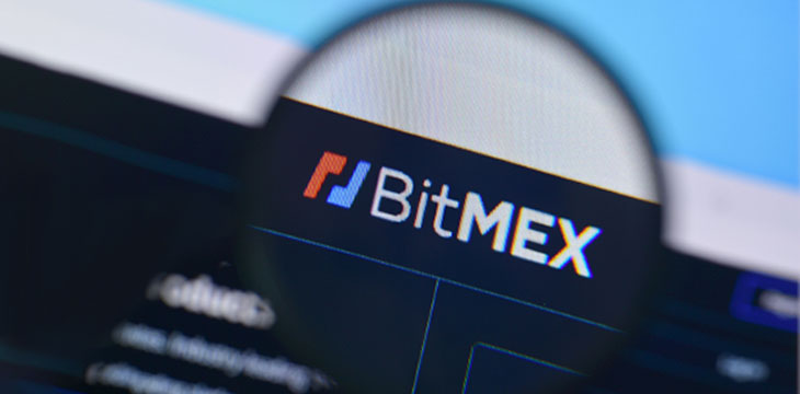 BitMEX website displayed on-computer-screen with magnifying glass over BitMEX logo verification concept
