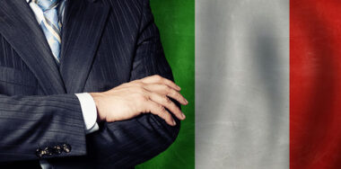 Crossed arms of politician on Italian flag background