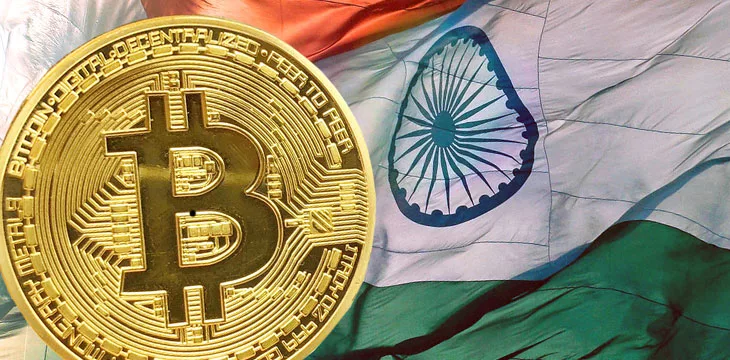 Close up image of golden Bitcoin with flag of India in the background