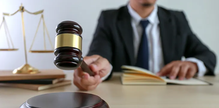 man holding a gavel and law book