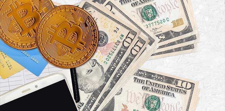 10 US dollars bills and golden bitcoins cryptocurrency investment concept