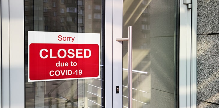 Business center closed due to COVID-19, sign with sorry in door window.