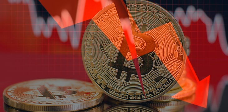 Bitcoin cut in half against a background on a downward arrow