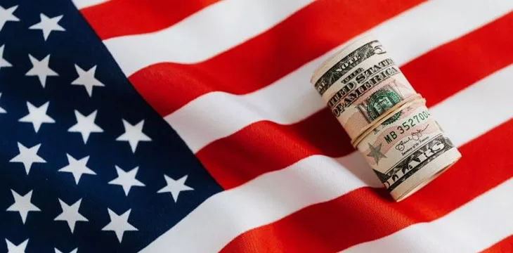 roll of dollars on top of american flag