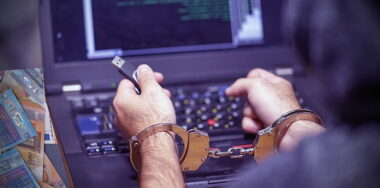 Photo of a man in cuffs facing a laptop