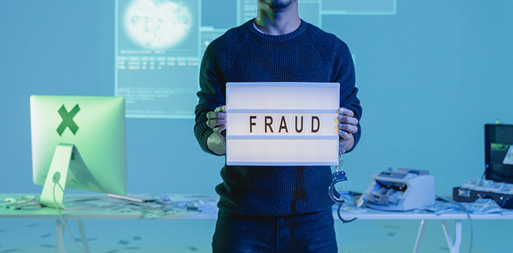 A man holding a box with the word fraud