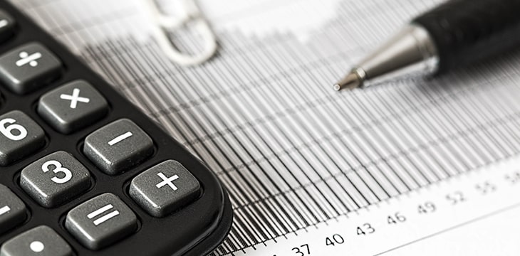 Zoomed photo of a calculator and pen over a piece of ledger