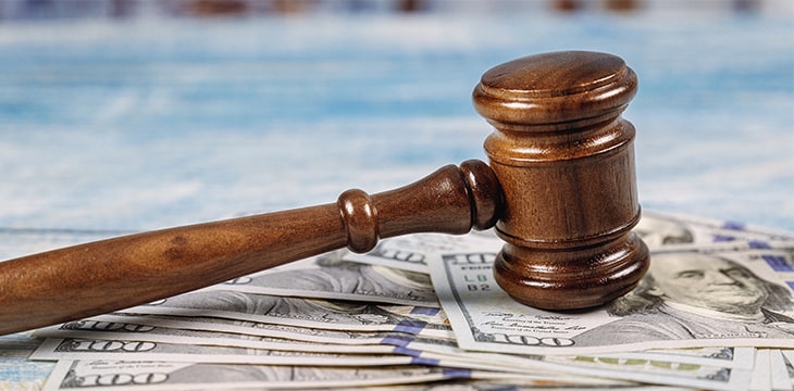 Court wooden gavel and money on blue background.