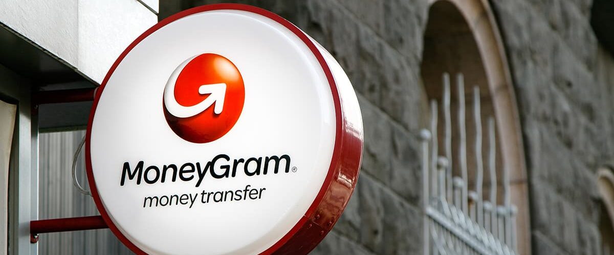 MoneyGram sign is mounted to a wall above the entrance to their branch
