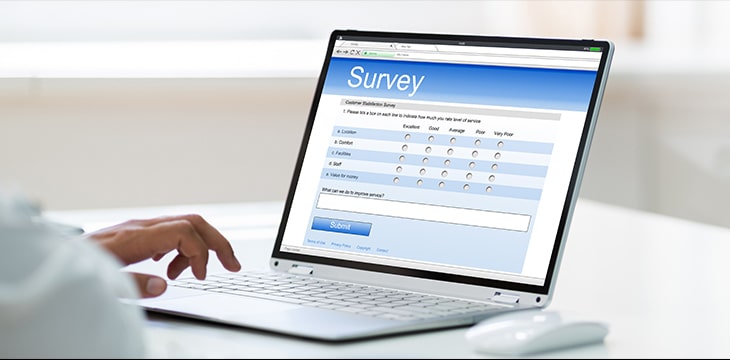 Photo of a person answering a survey on a laptop