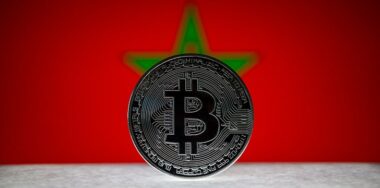 Physical silver version of Bitcoin BTC and Morocco Flag on the background.