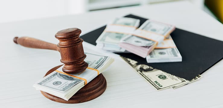 Selective focus of gavel of judge near dollar banknotes on table