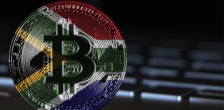 Bitcoin close-up on keyboard background, the flag of South Africa is shown on bitcoin.