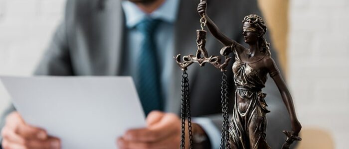 Close-up view of lady justice statue and lawyer working