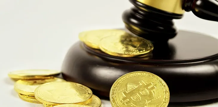 Golden bitcoins and judge gavel on white background