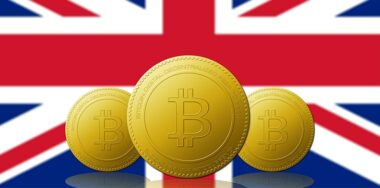 Three Bitcoin cryptocurrency with UNITED KINGDOM flag on background.