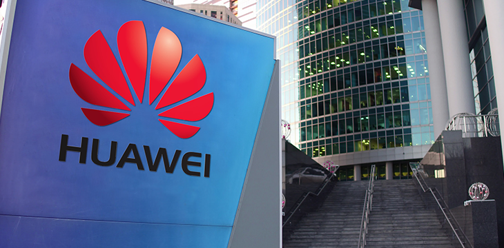 Street signage board with Huawei logo.