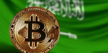 bitcoin with flag of saudi arabia behind it