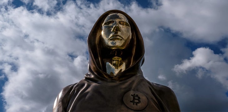 A statue of a person with a cloudy sky behind him