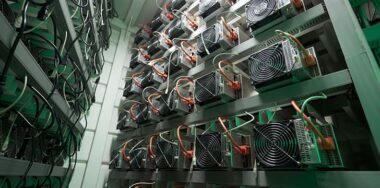 Bitcoin miners in large farm. ASIC mining equipment on stand racks mine cryptocurrency in steel container. Blockchain techology application specific integrated circuit datacenter. Server room lights.