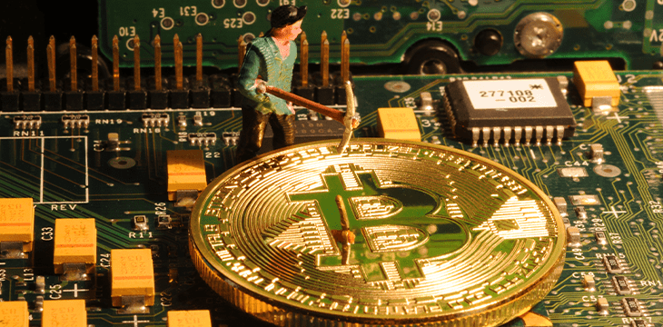 Aminer toy on a motherboard with bitcoin coins