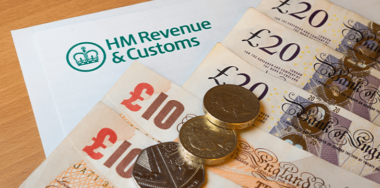 Euro bank notes and coins with HM revenue and customs word