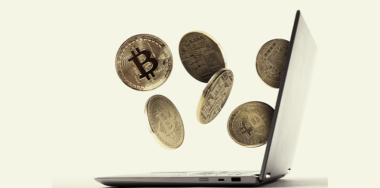Coins of Bitcoin are falling from laptop screen.