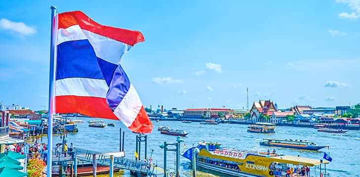 The Thailand flag sways in the wind on the bank of Chao Phraya