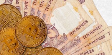 10 Indian rupees bills and golden bitcoins.