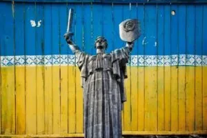 A statue holding a sword and a shield with Ukrainian flag color motif