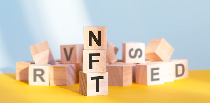 Wooden cubes with letters NFT arranged in a vertical pyramid