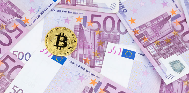 Golden bitcoin on pile of five hundred euro