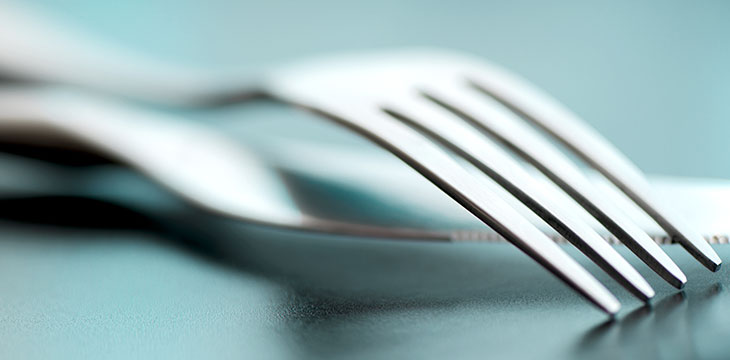Artistic cutlery fork and knife macro on plate