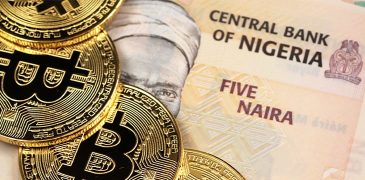 A close up image of Nigerian 5 Naira bank notes with gold Bitcoins