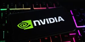 Closeup of mobile phone screen with logo lettering of nvidia corporation on computer keyboard.