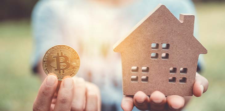 Copyspace model of a little house and a symbol of cryptocurrency that woman holds it background. Deam life have own house property for living or investment concept.