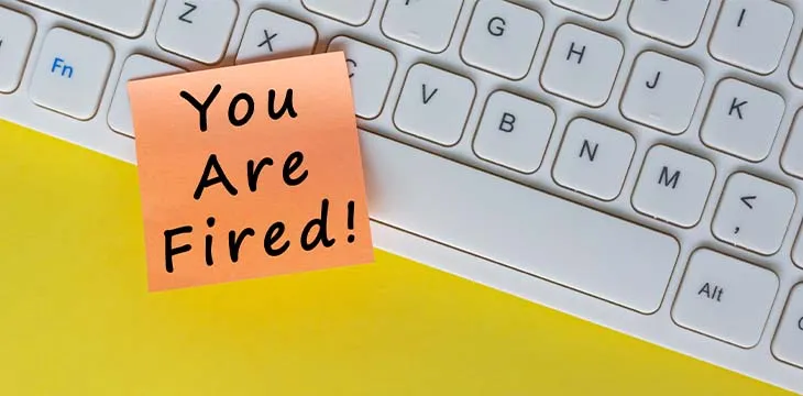 You're Fired text on orange sticky note on top of white keyboard