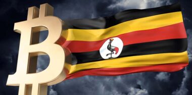 Gold bitcoin cryptocurrency with a waving Uganda flag