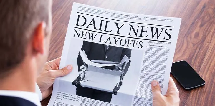 Close-up Of Businessman Reading News of Layoffs