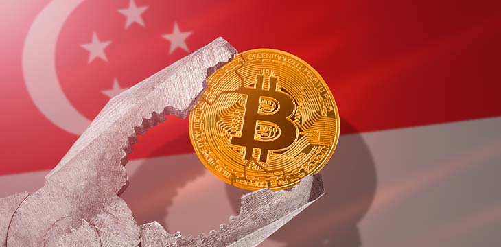 Bitcoin regulation in Singapore; bitcoin btc coin being squeezed in vice on Singapore flag background; limitation, prohibition, illegally, banned