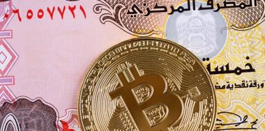 A United Arab Emirates five dirham note with Bitcoin coin