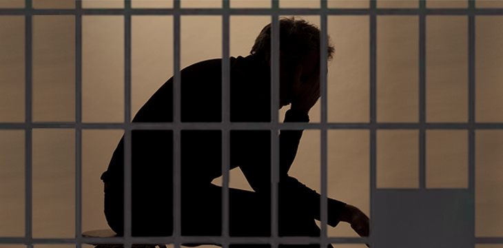 Prisoner in prison with silhouette behind the bars