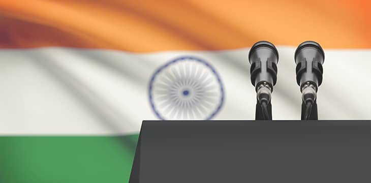 Pulpit and two microphones with a national flag of India on background.
