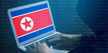 Hacker working with laptop at table. Flag of North Korea