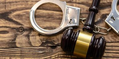 Handcuffs and gavel on wooden surface