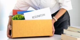 Employee holding a box with resignation letter on top