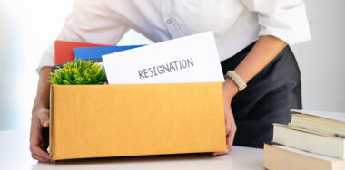 Employee holding a box with resignation letter on top