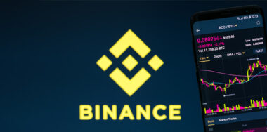 Binance mobile app on running on smartphone with Binance Logo on background