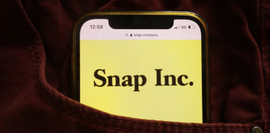 Snap Inc logo displayed on mobile phone hidden in jeans pocket